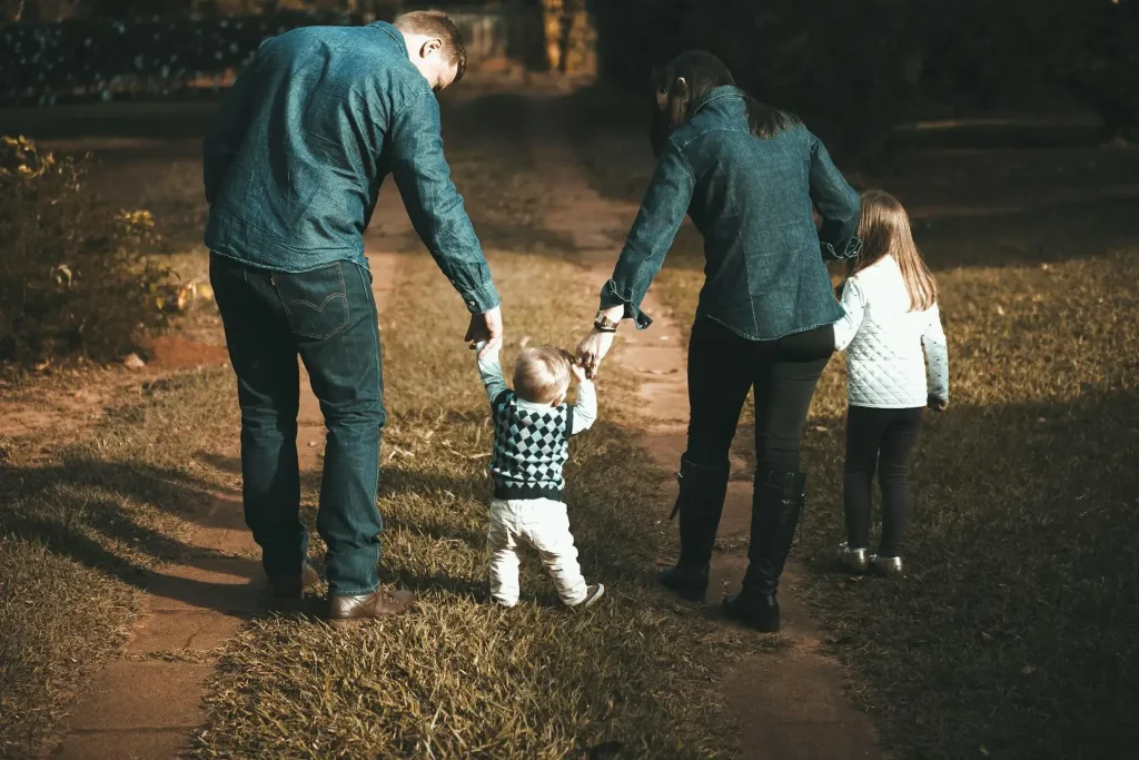 Pais e filhos caminhando de mãos dadas em um caminho de terra