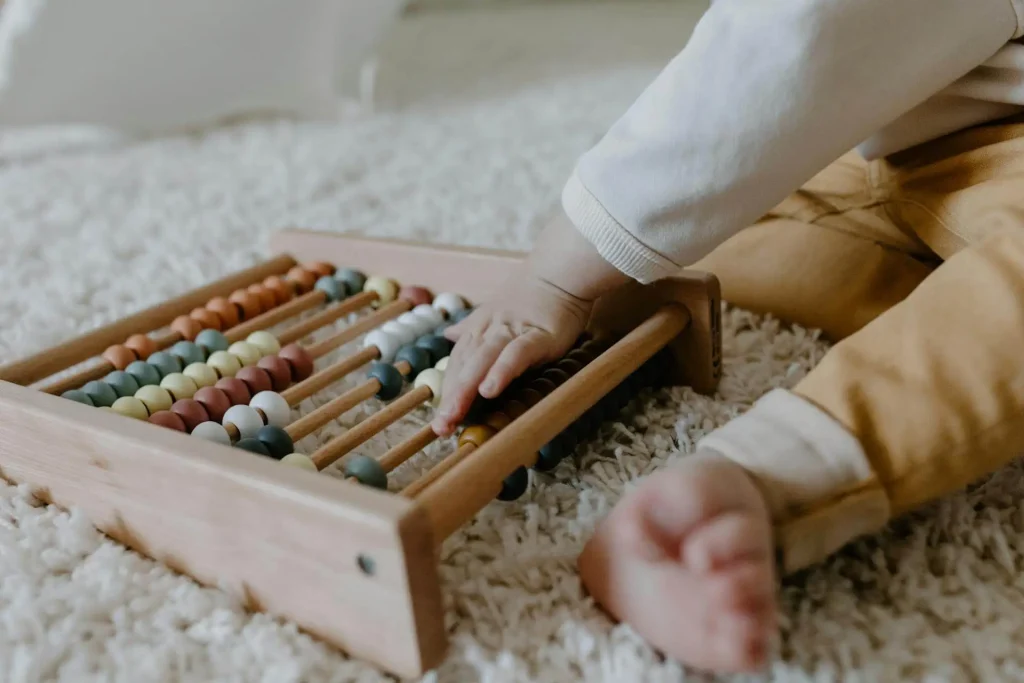 Bebê brincando com ábaco de madeira