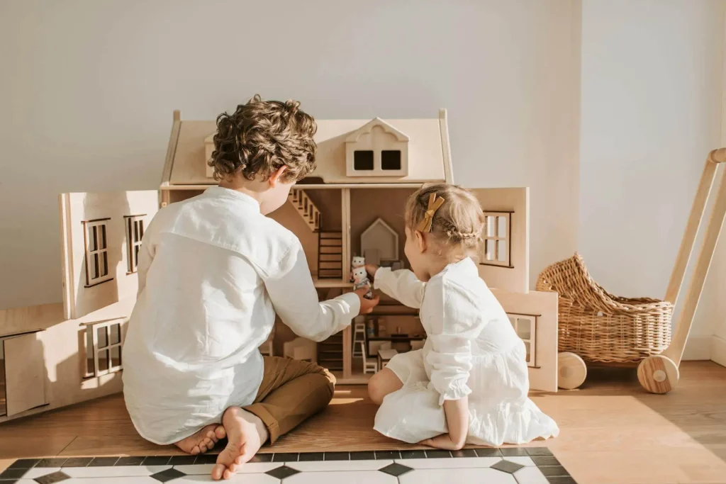 Crianças brincando com casinha de madeira
