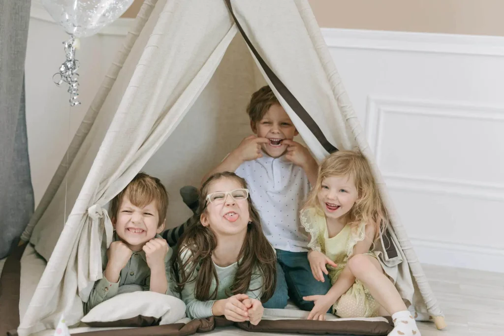 Quatro crianças felizes dentro da cabana de acampamento