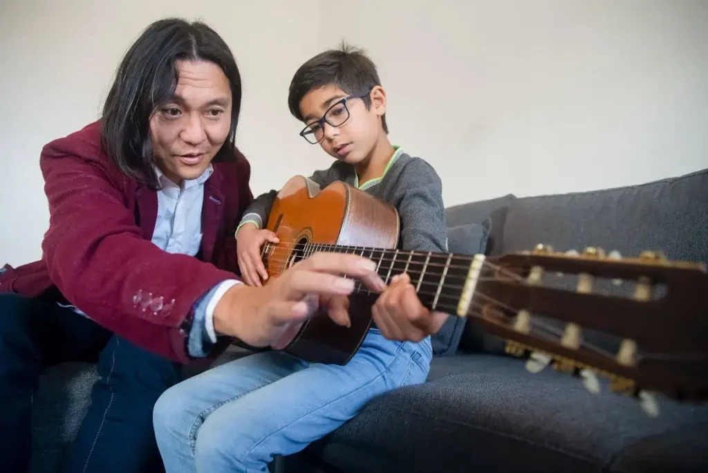 Menino estudando música clássica no vioção com seu professor